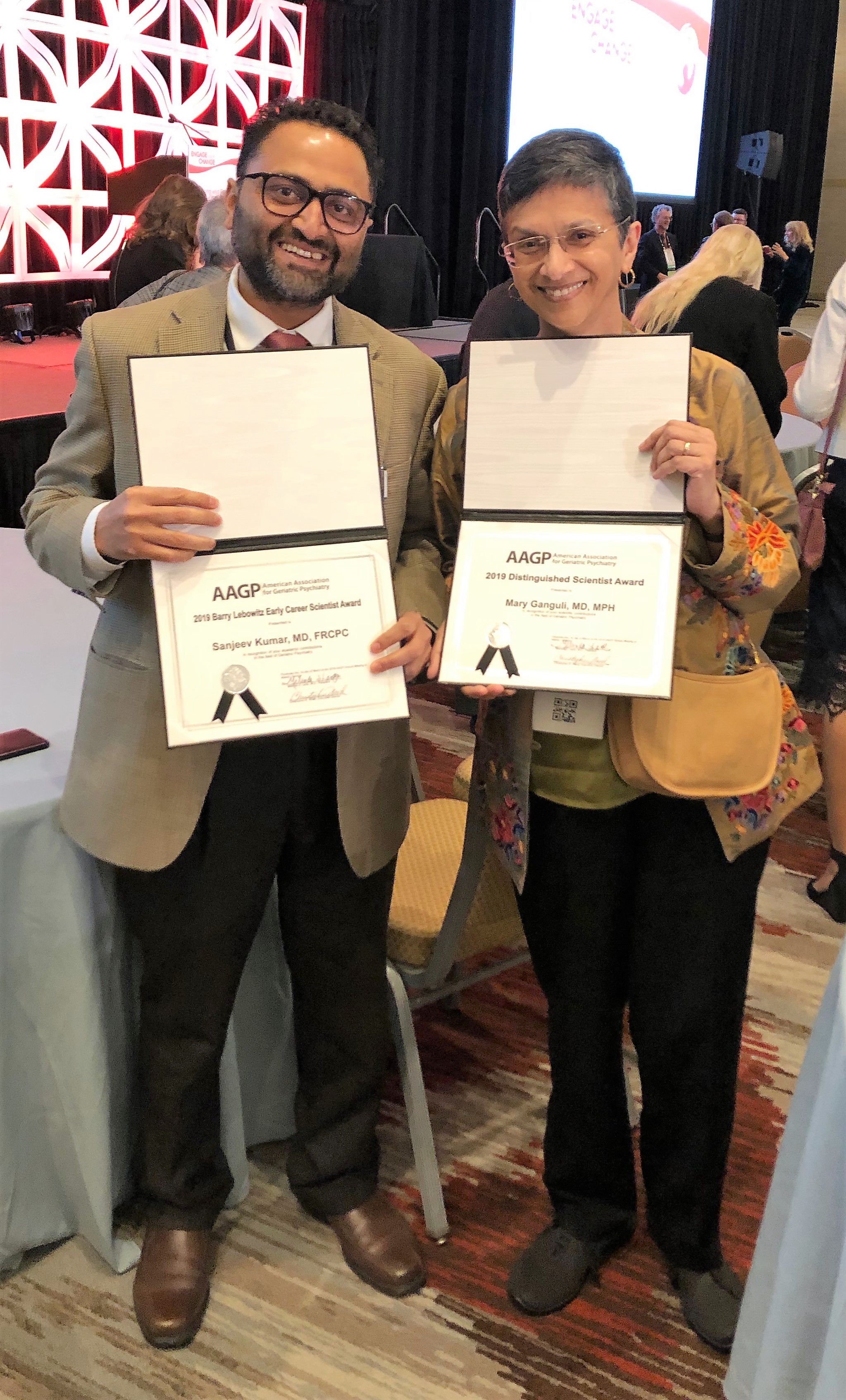 Drs. Sanjay Kumar and Mary Ganguli display their 2019 AAGP Awards